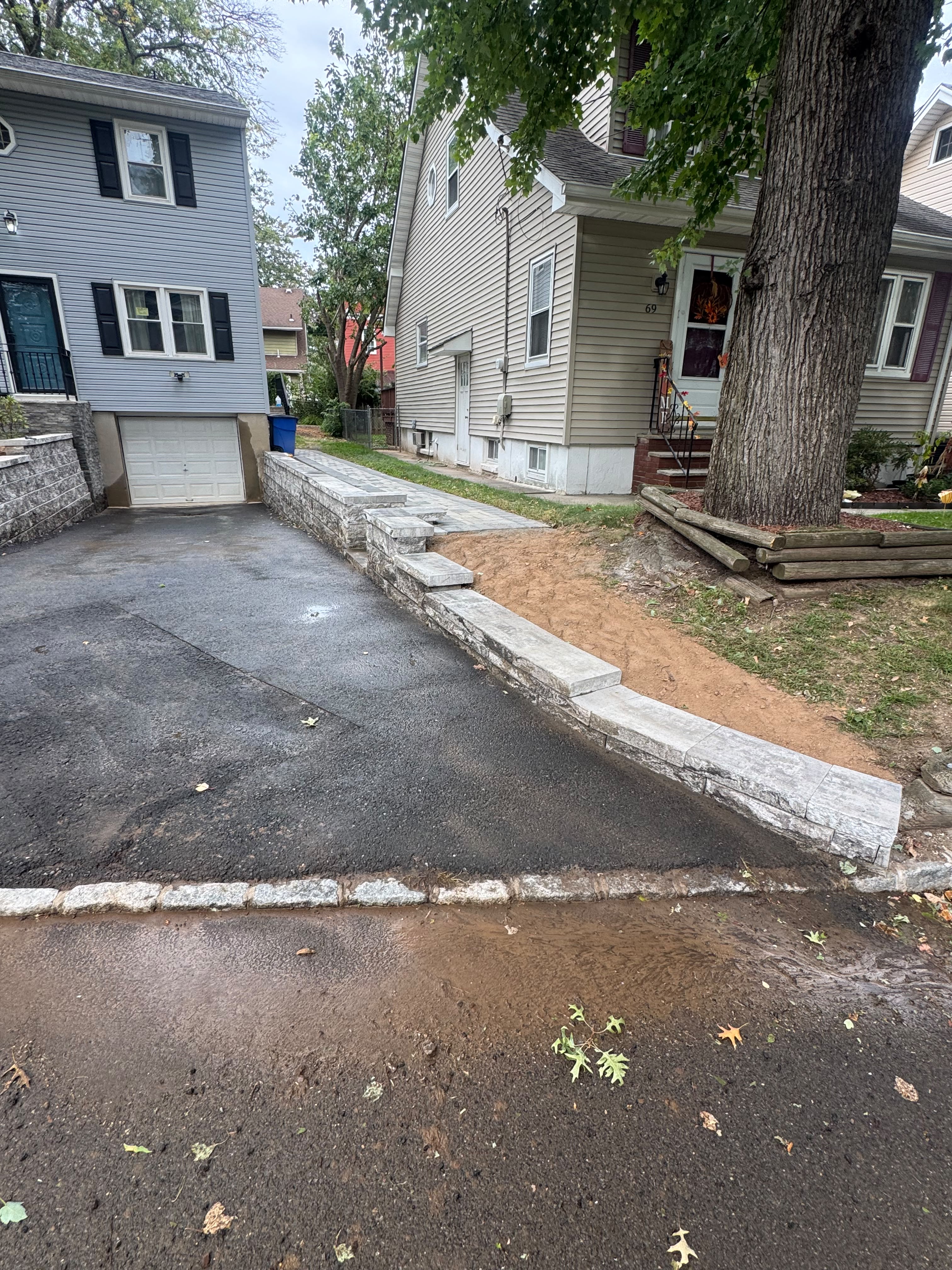 Stone retaining wall and paver walkway by Tames Tree Services Masonry and Landscaping