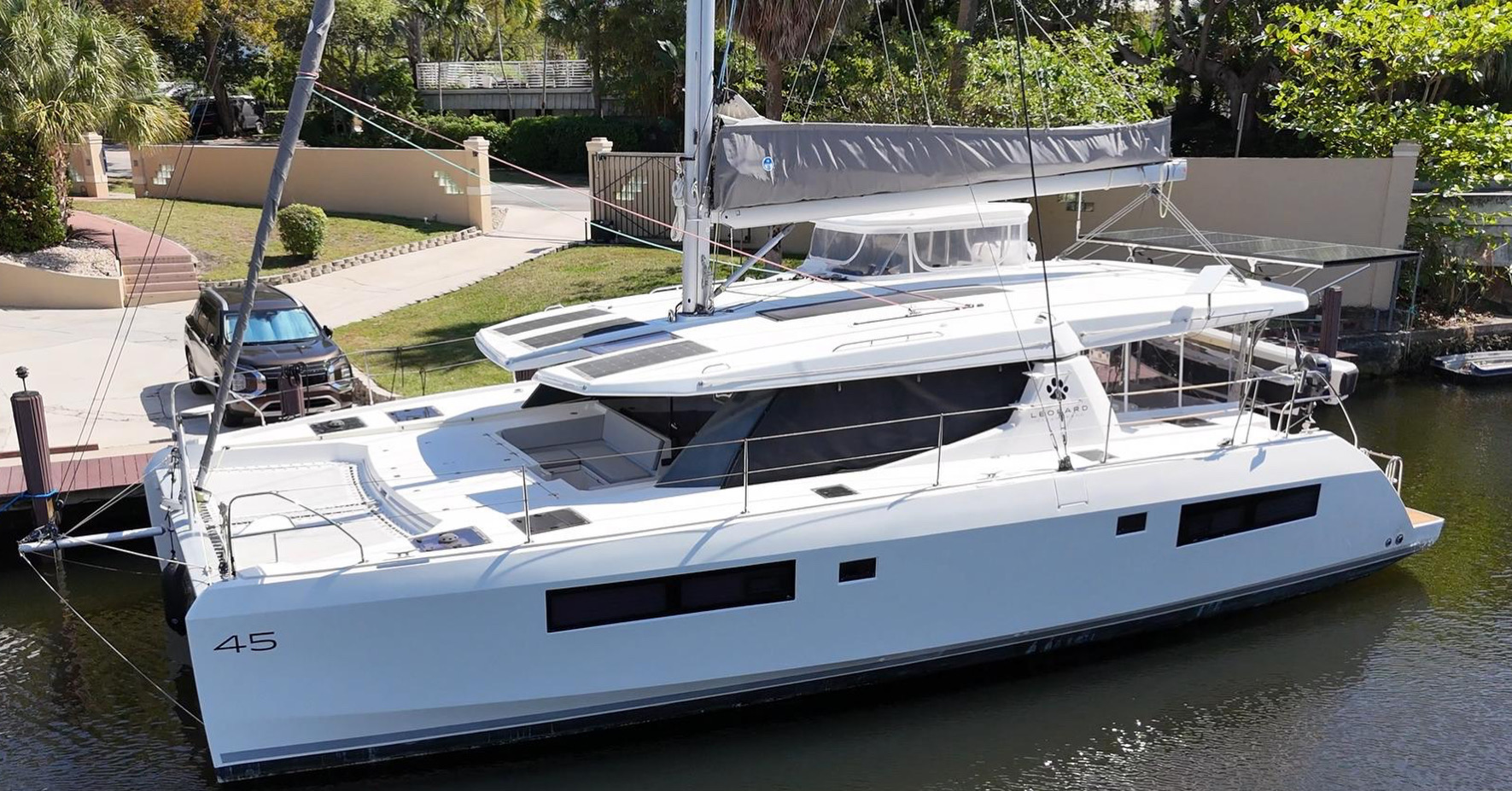 White Leopard 45 catamaran in vivid turquoise Caribbean water with tropical island background