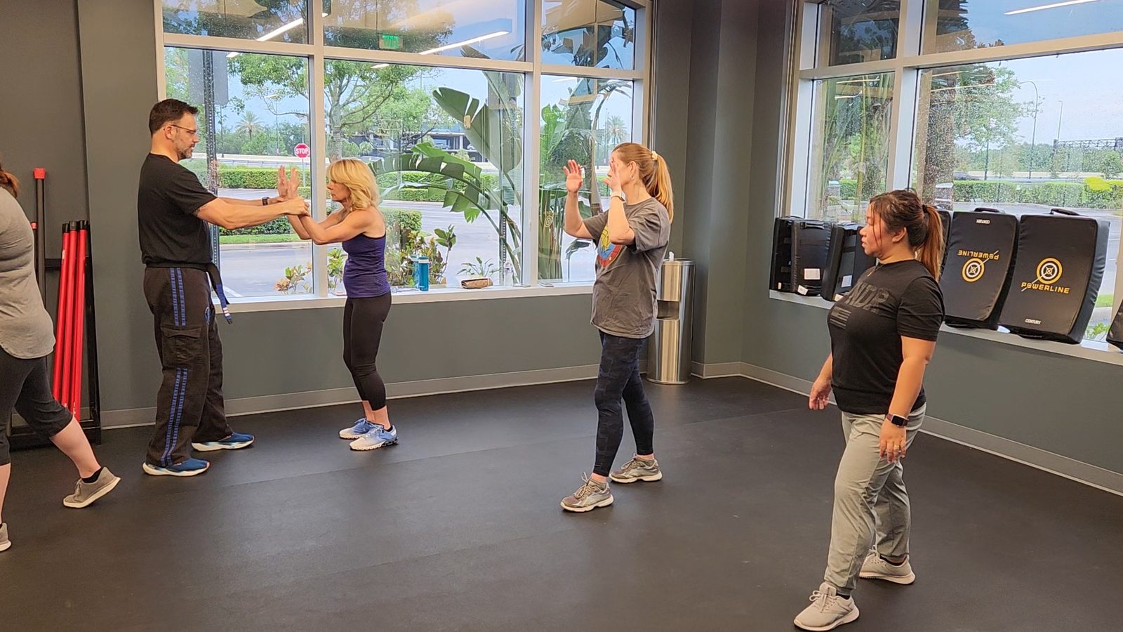 Jason Mertin teaching a wrist-release technique, with a small group mirroring the movement