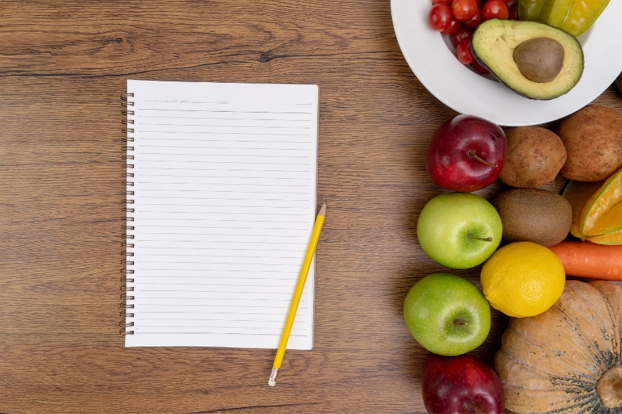notepad and bowl of fruit