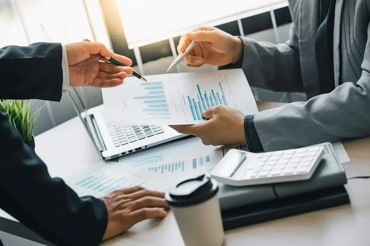 Conseiller en gestion de patrimoine analysant des graphiques financiers avec un client, illustrant l’optimisation des placements financiers à Lyon.