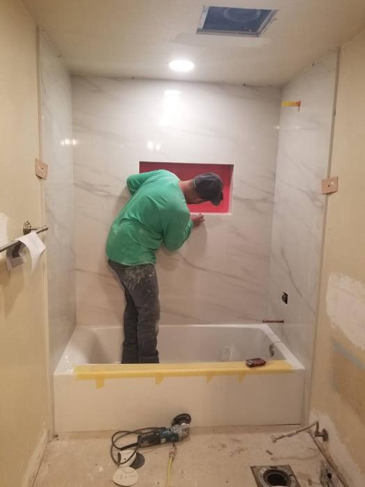 Tile installer working in a bathroom on a client job site