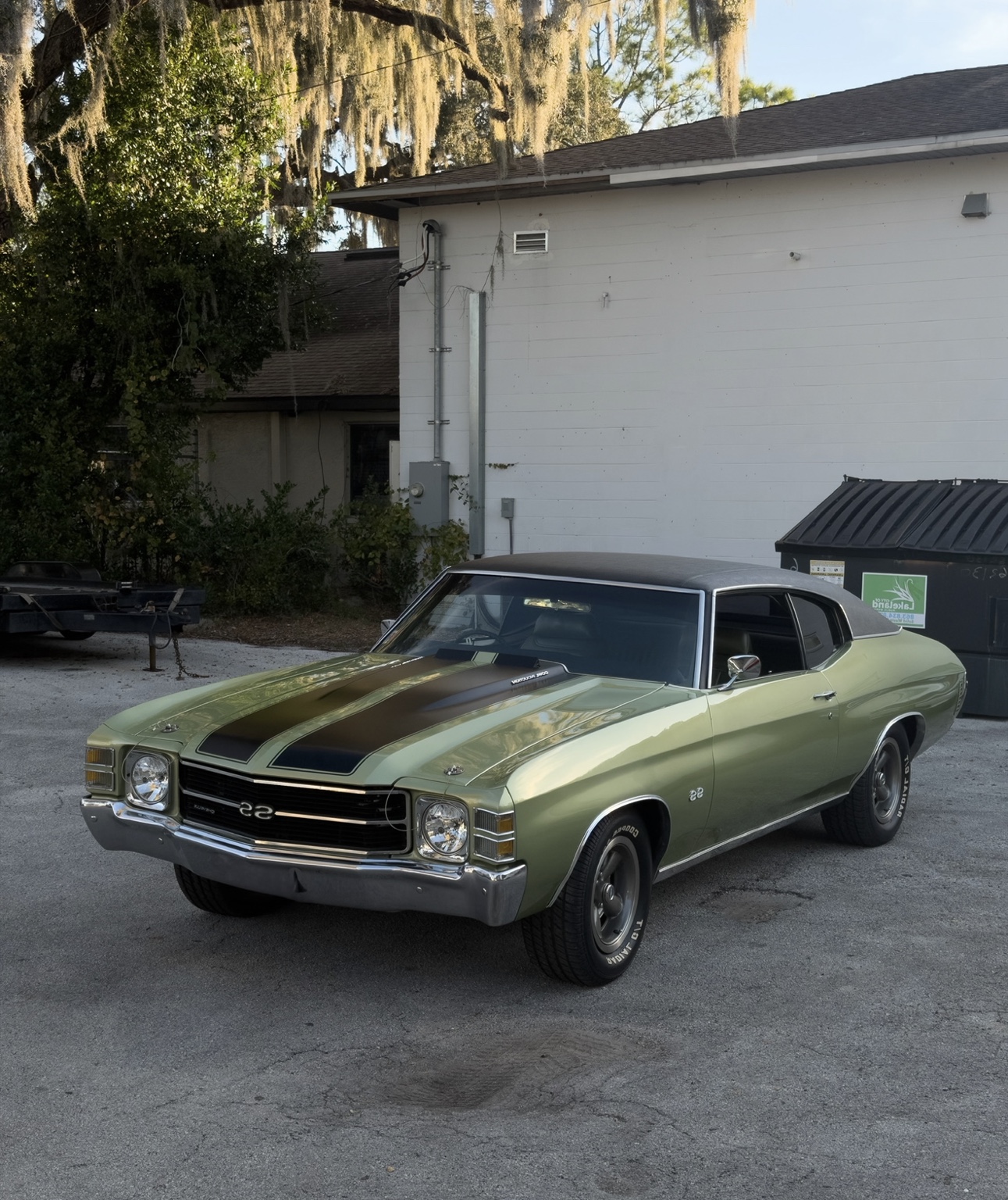 Green classic American muscle car at a home