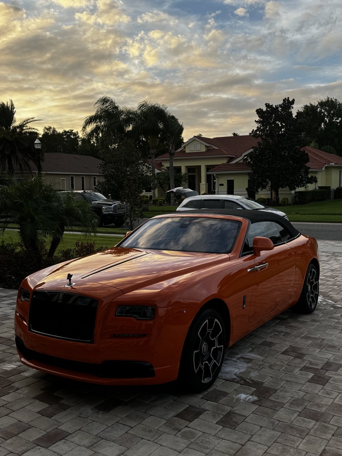 Orange Rolls-Royce in a residential driveway