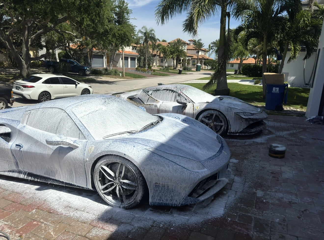 Foam wash on two high-performance cars at a residential detailing location