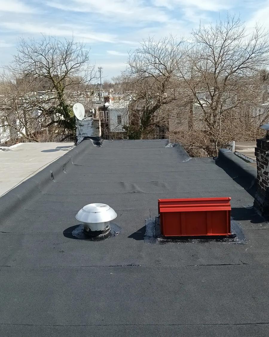 New flat roof with a red skylight curb and a re-set turbine vent