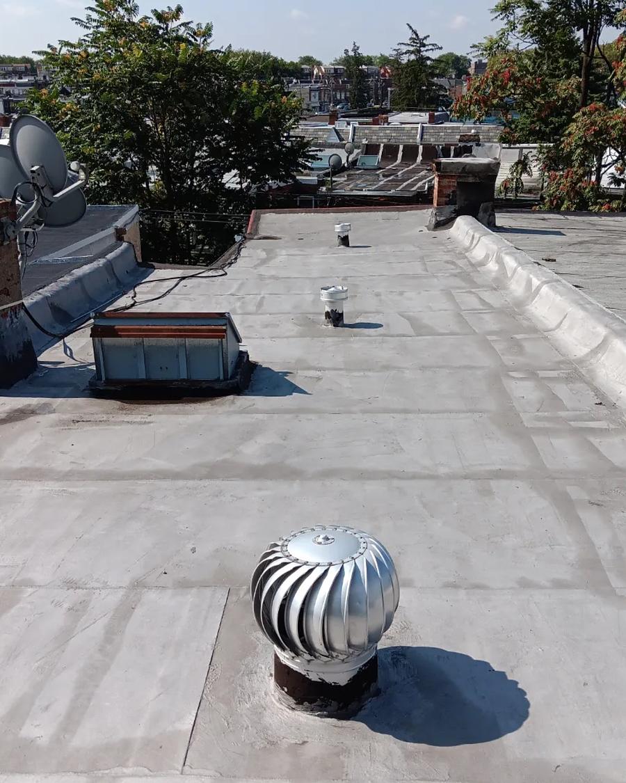 Old silver-coated roof surface around a turbine vent, before tear-off