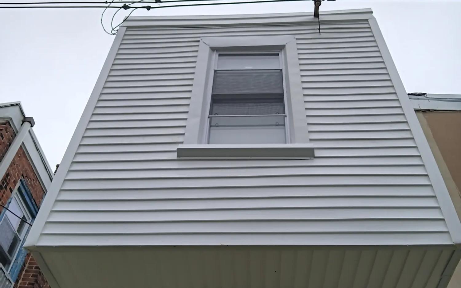 New white vinyl siding and capping on a Philadelphia row home dormer