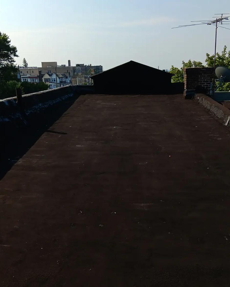 Dried-out brown flat roof under an overcast sky, before coating