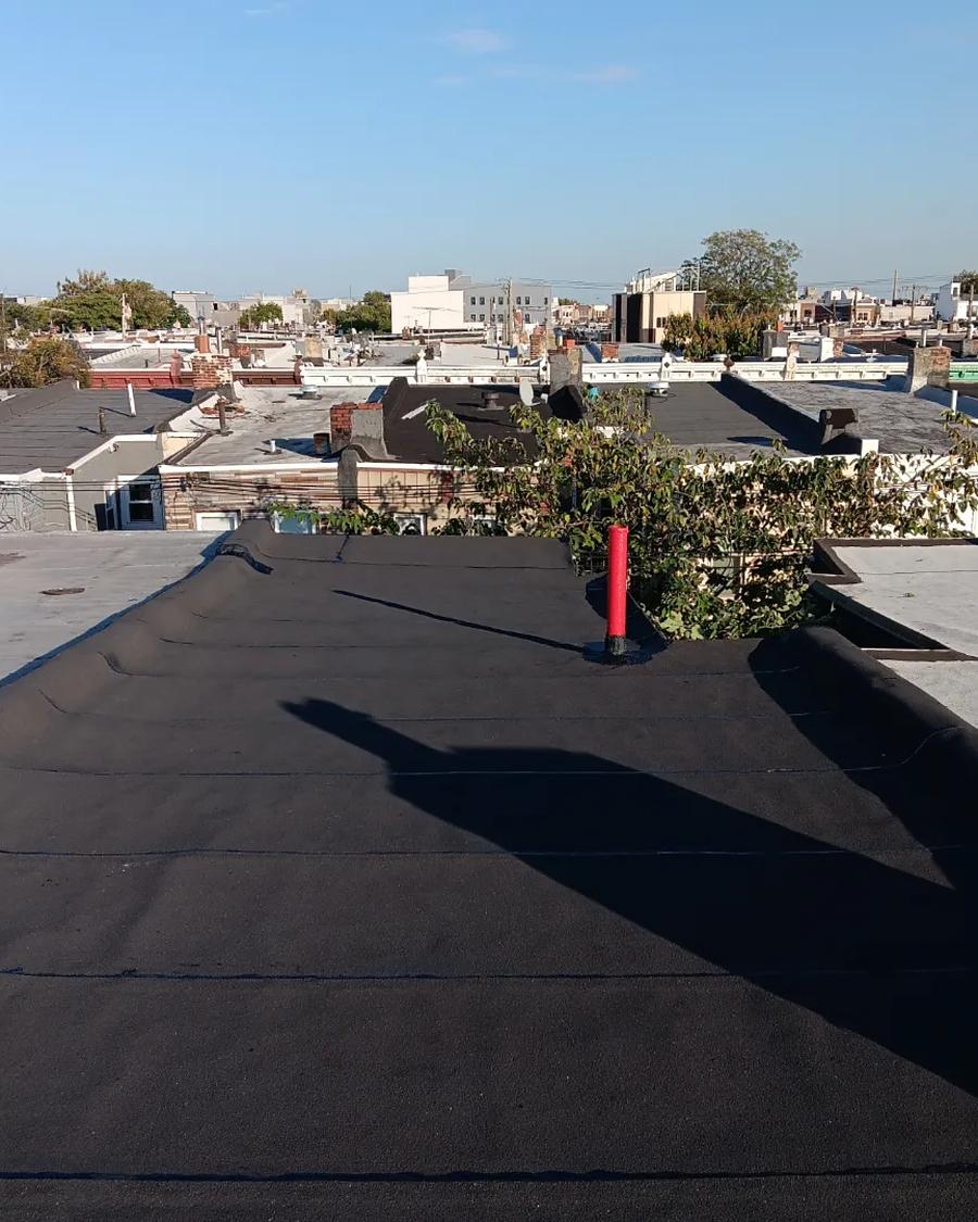 New granulated torch-down flat roof with a fresh red pipe boot