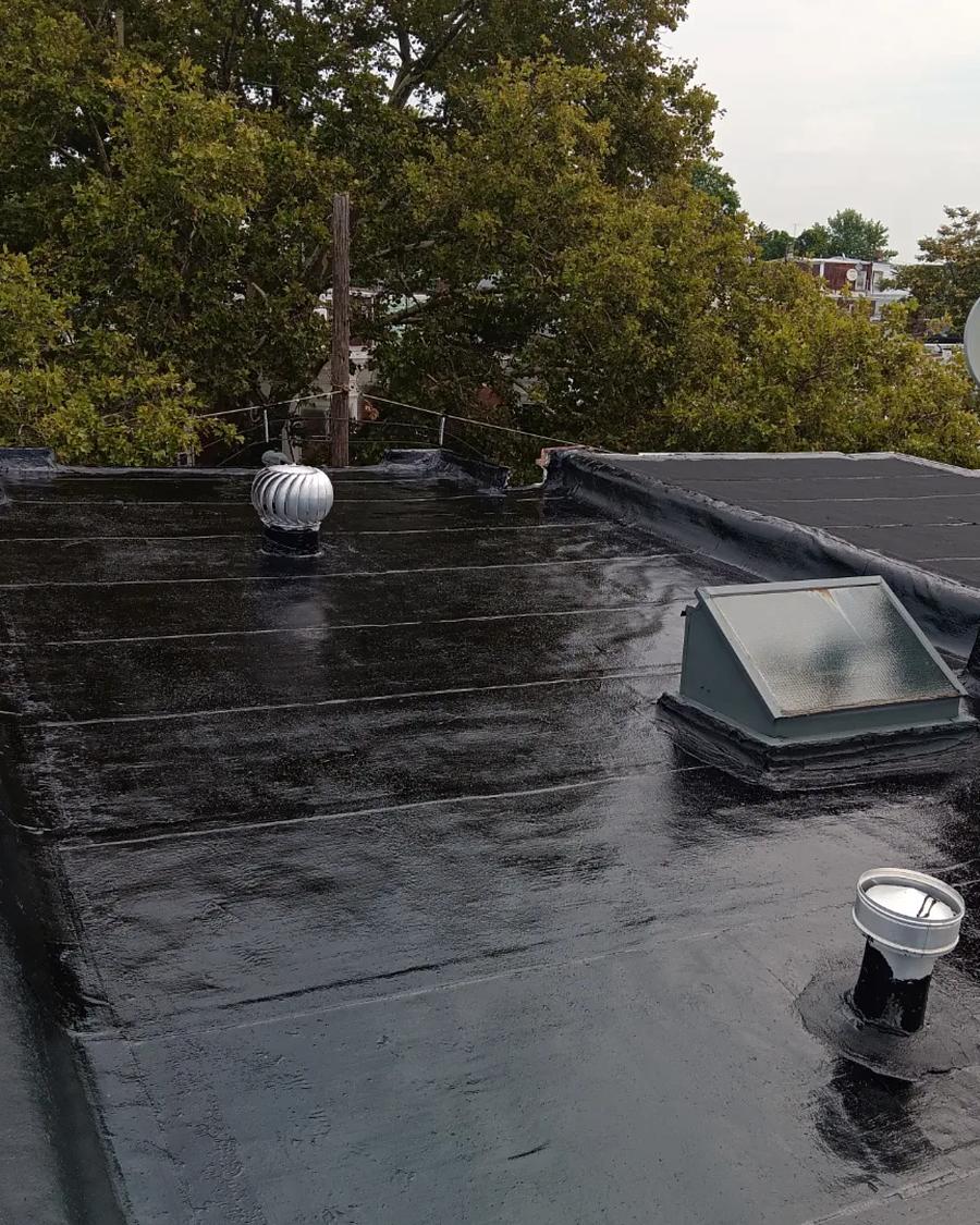 New black rubber roof membrane laid around the skylight and vents