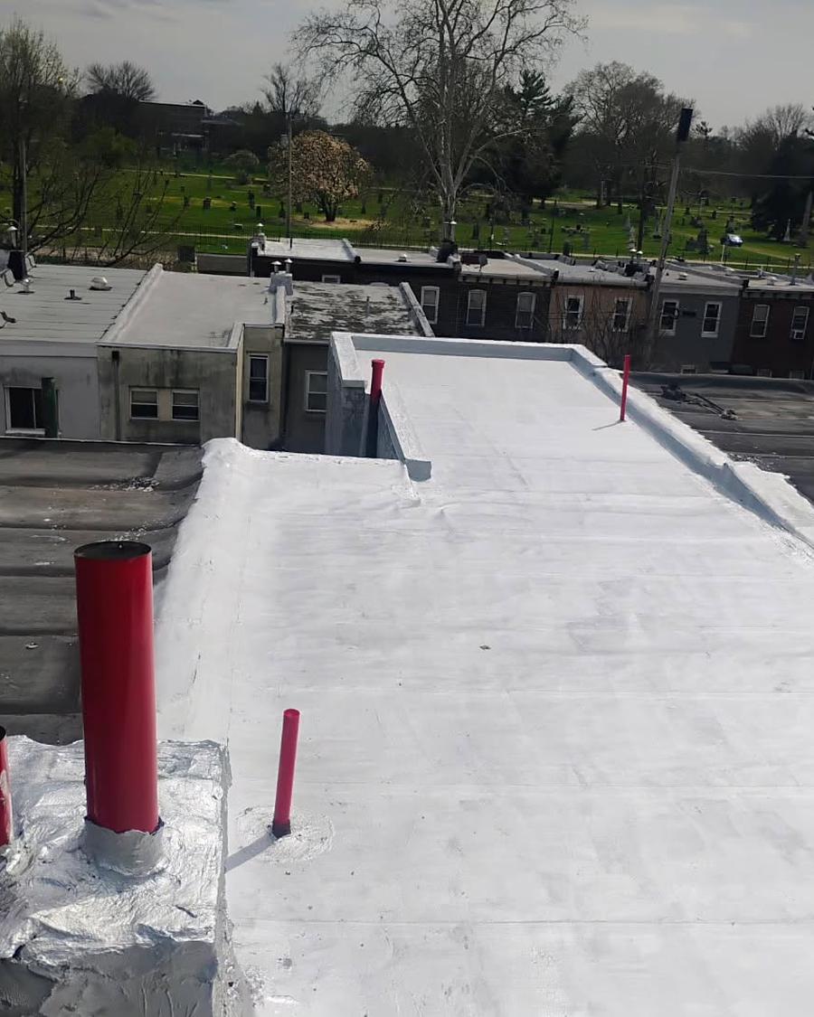 The same roof after a full white coating, red pipe boots reset