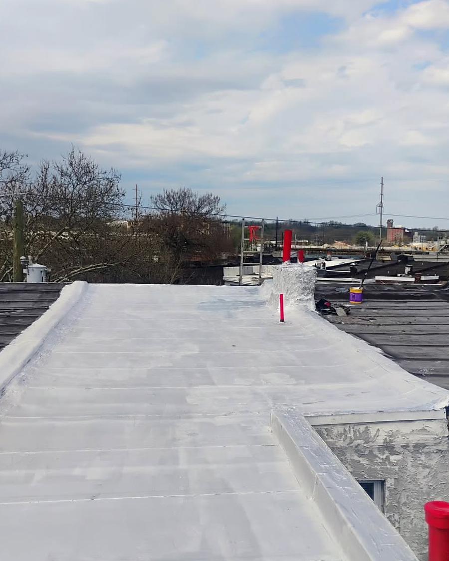 Finished white-coated flat roof with new pipe collars