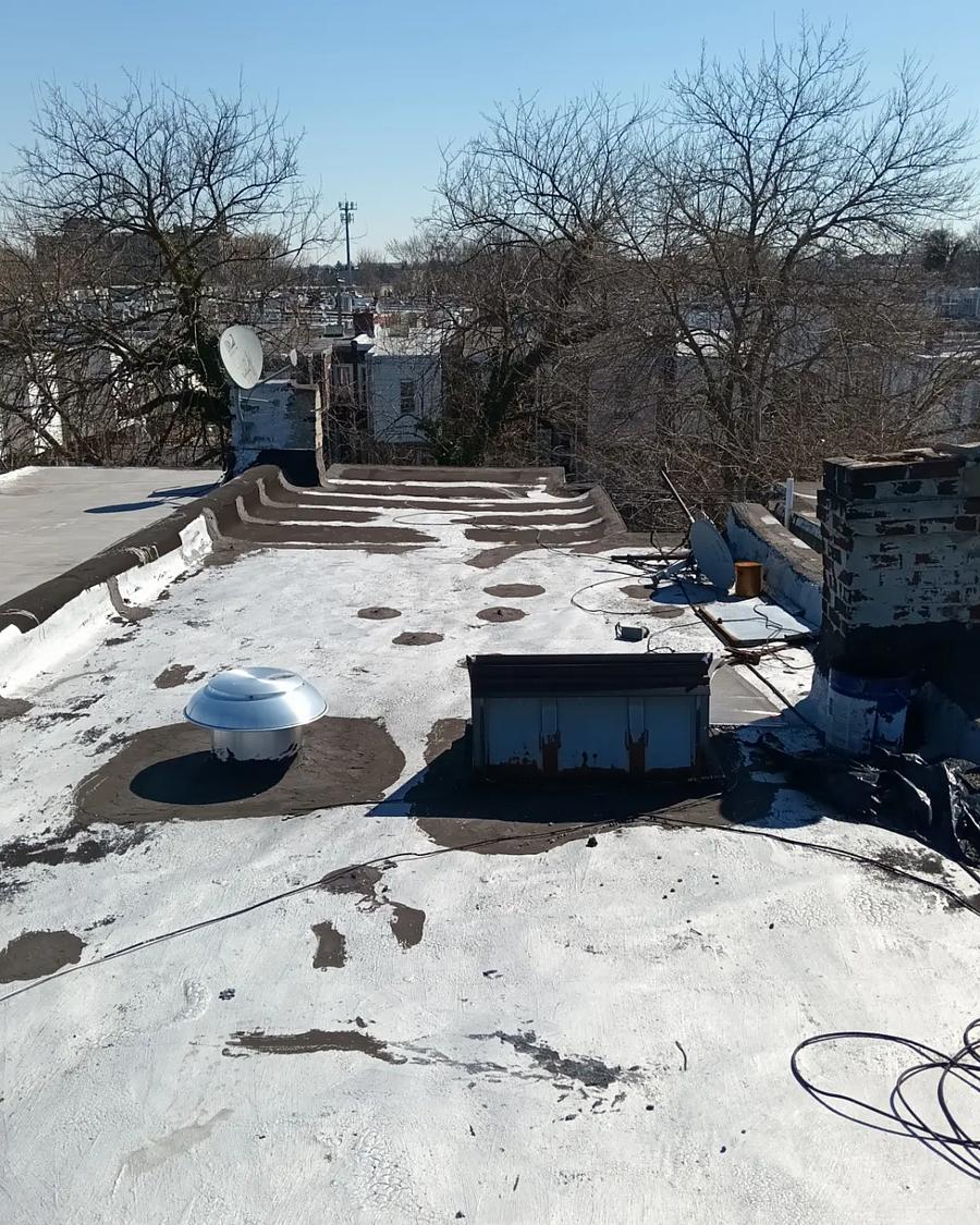 Patchy, failing roof surface with snow still on it before tear-off