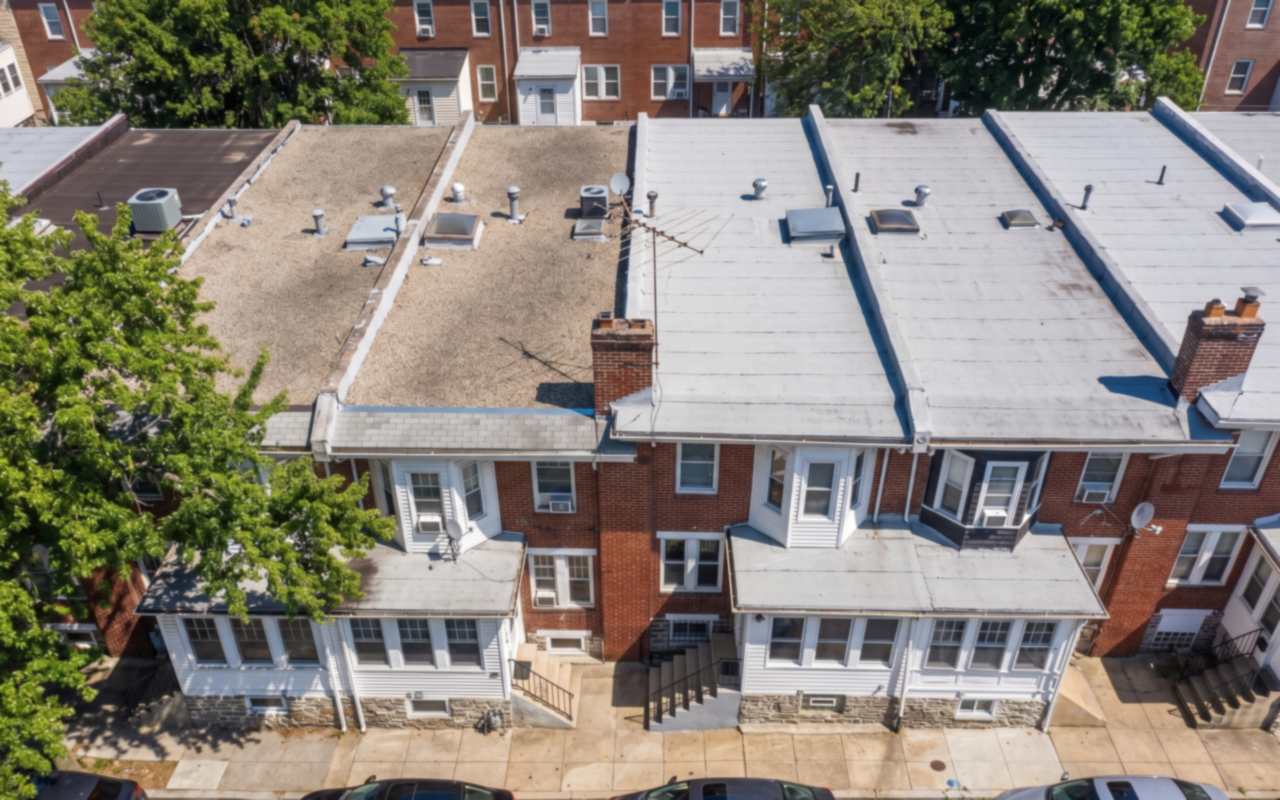 Unbroken brick rows with low-slope roofs and party-wall parapets in Upper Darby, Delaware County