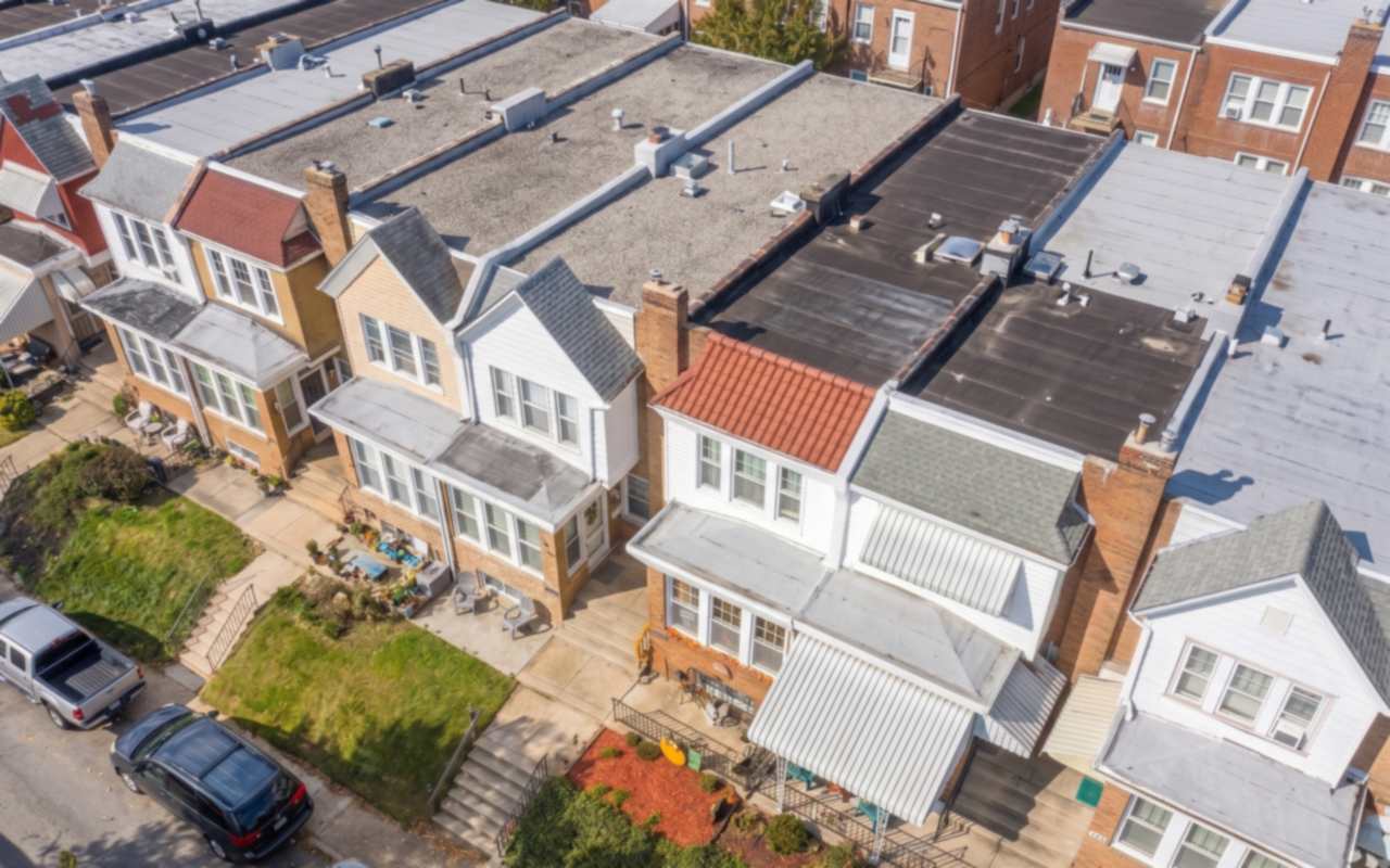 Hillside rows and twins with a mix of flat and pitched roofs above Roxborough and Manayunk