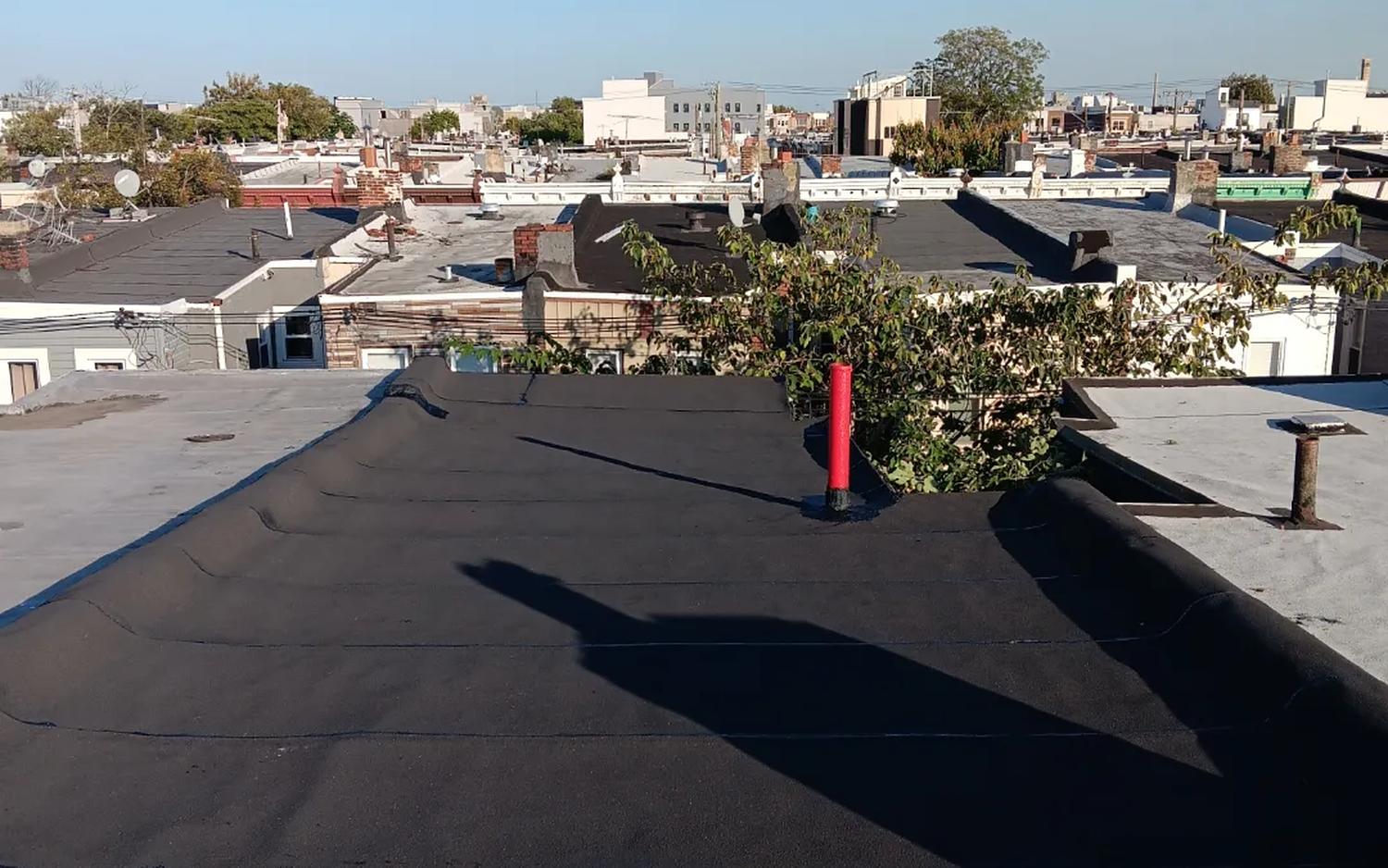Freshly installed torch-down flat roof on a Philadelphia row home