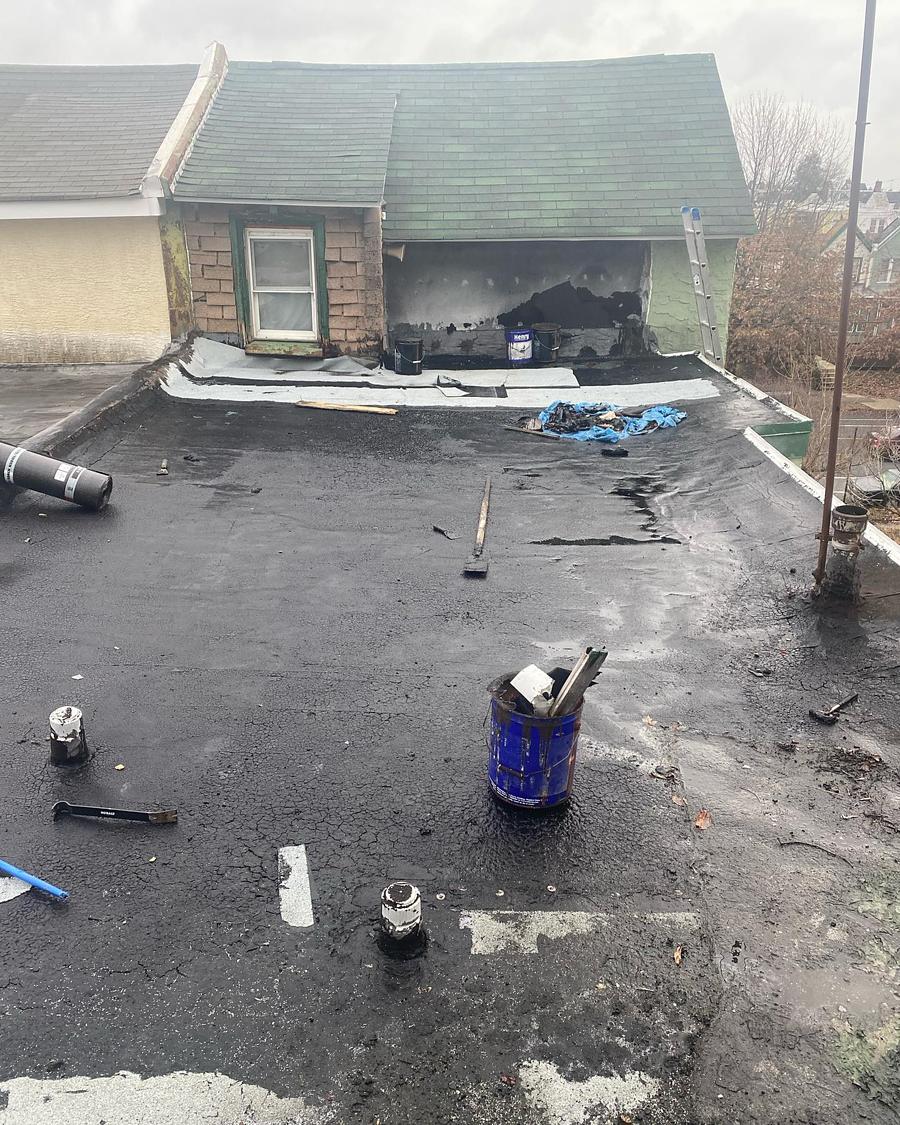 Roof stripped to the substrate, tools and buckets out, mid tear-off
