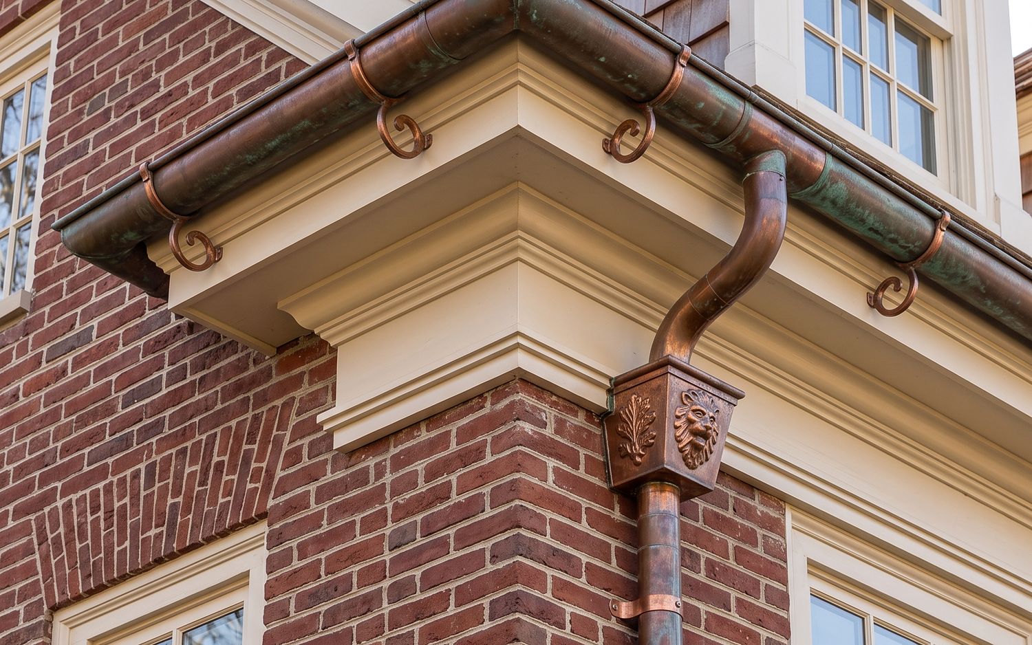 Solid copper gutter with soldered joints, weathering toward bronze