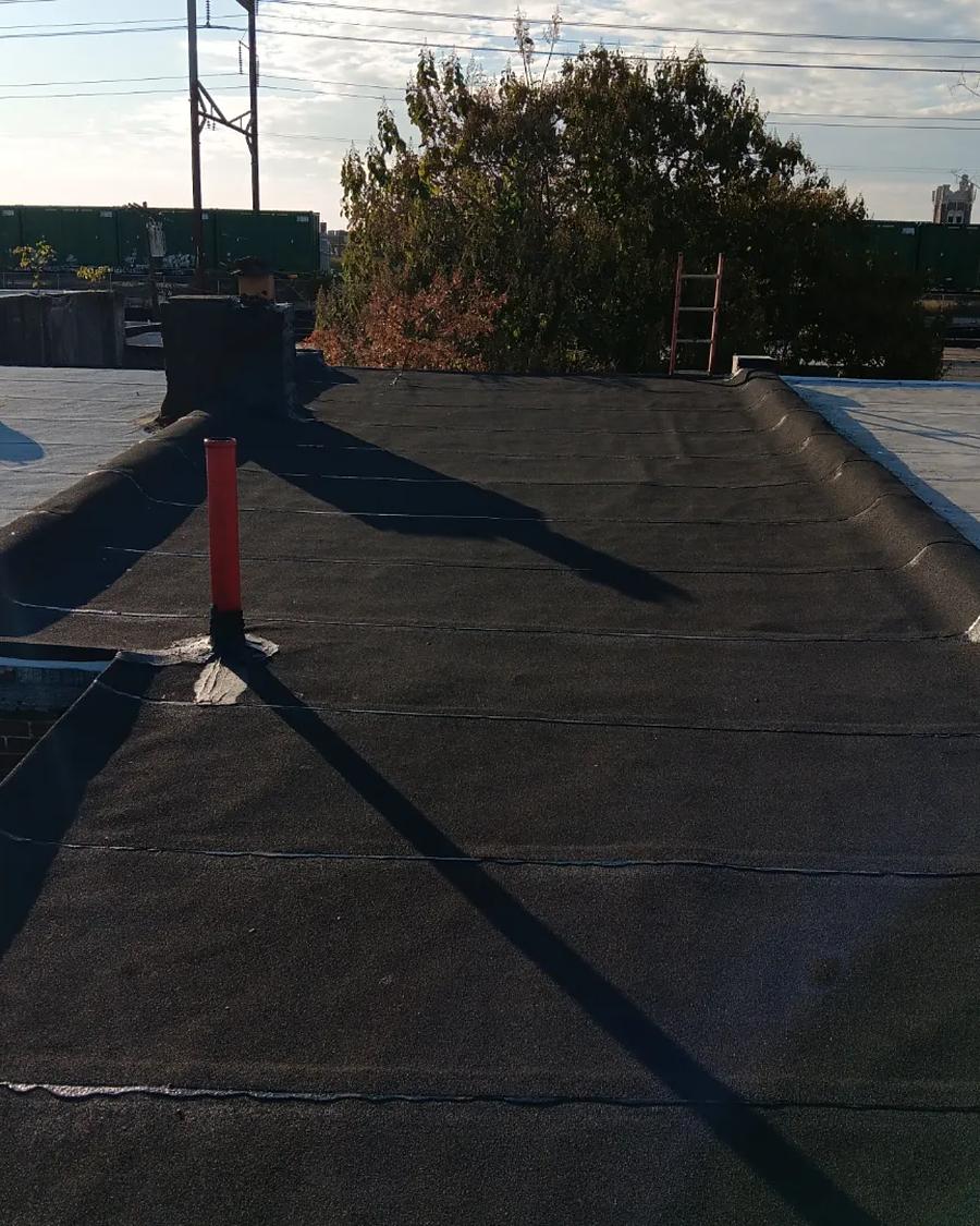 The same roof rebuilt in new torch-down membrane, clean to every edge