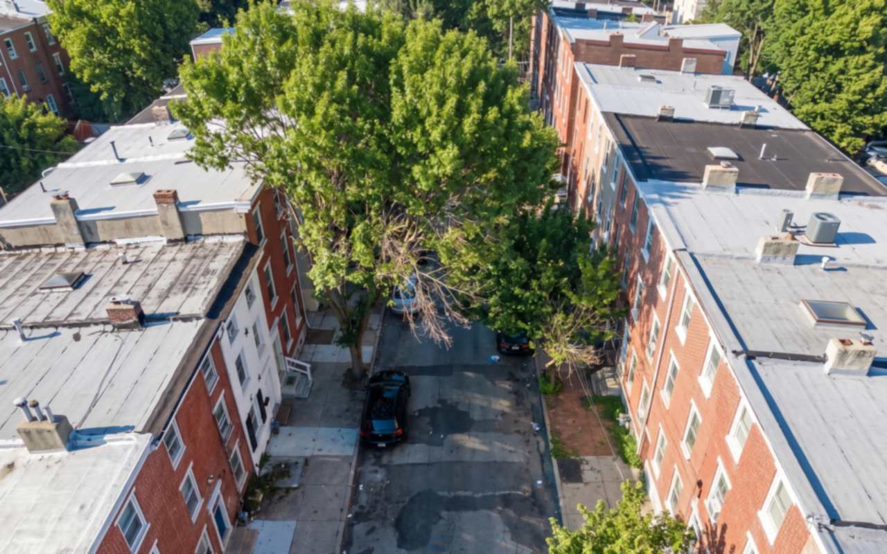 Brick and stone rows with flat roofs climbing a Norristown street in Montgomery County