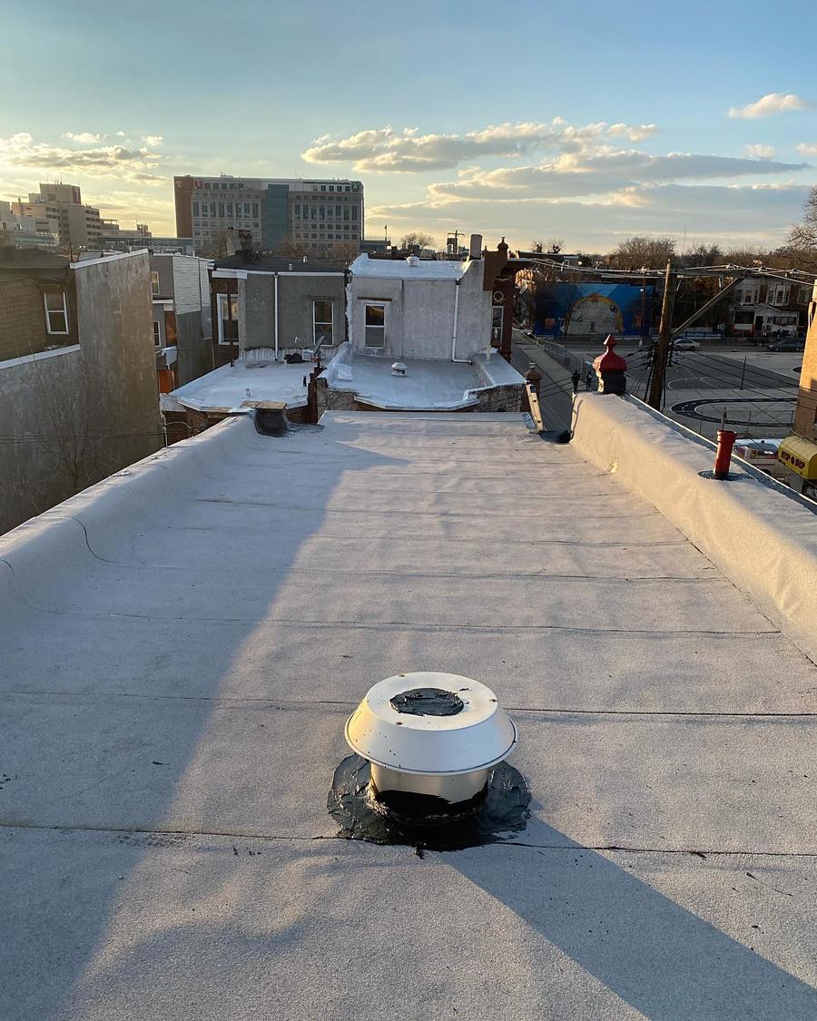 The same roof rebuilt and coated, vent re-flashed, at sunset