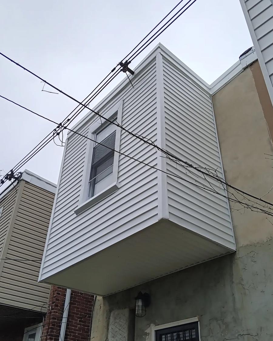 The same overhang re-sided in white vinyl, corners and trim capped