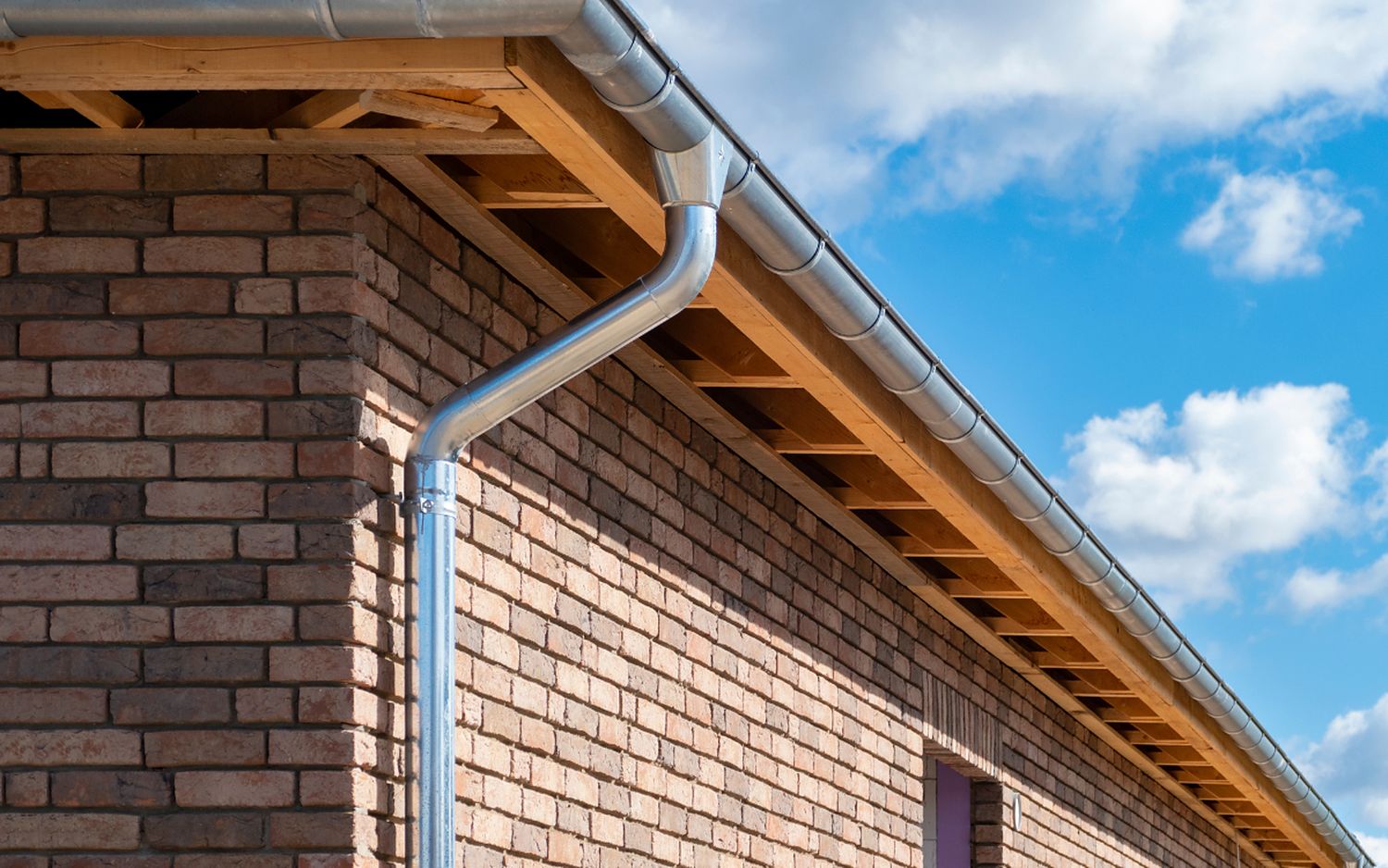 Seamless gutter and downspout on a residential roofline