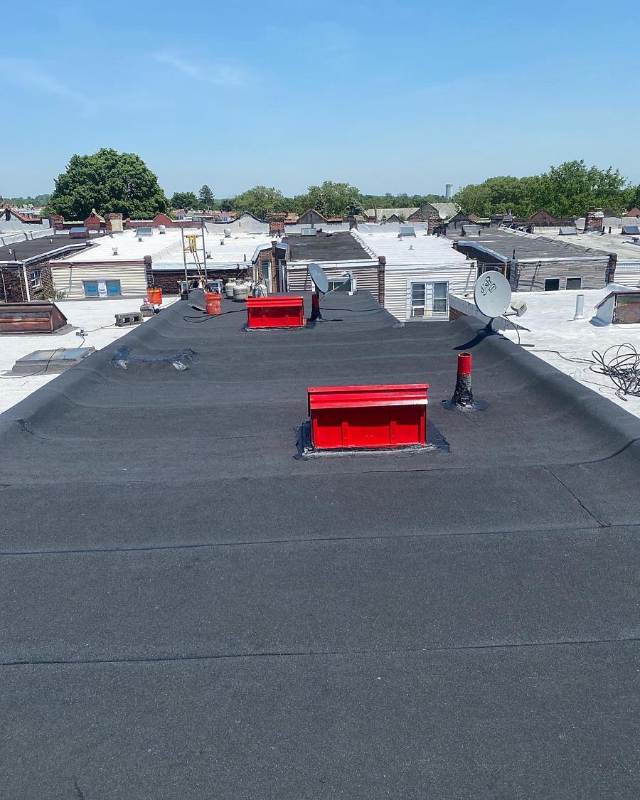 New flat roof with two red skylight curbs, summer, Philadelphia