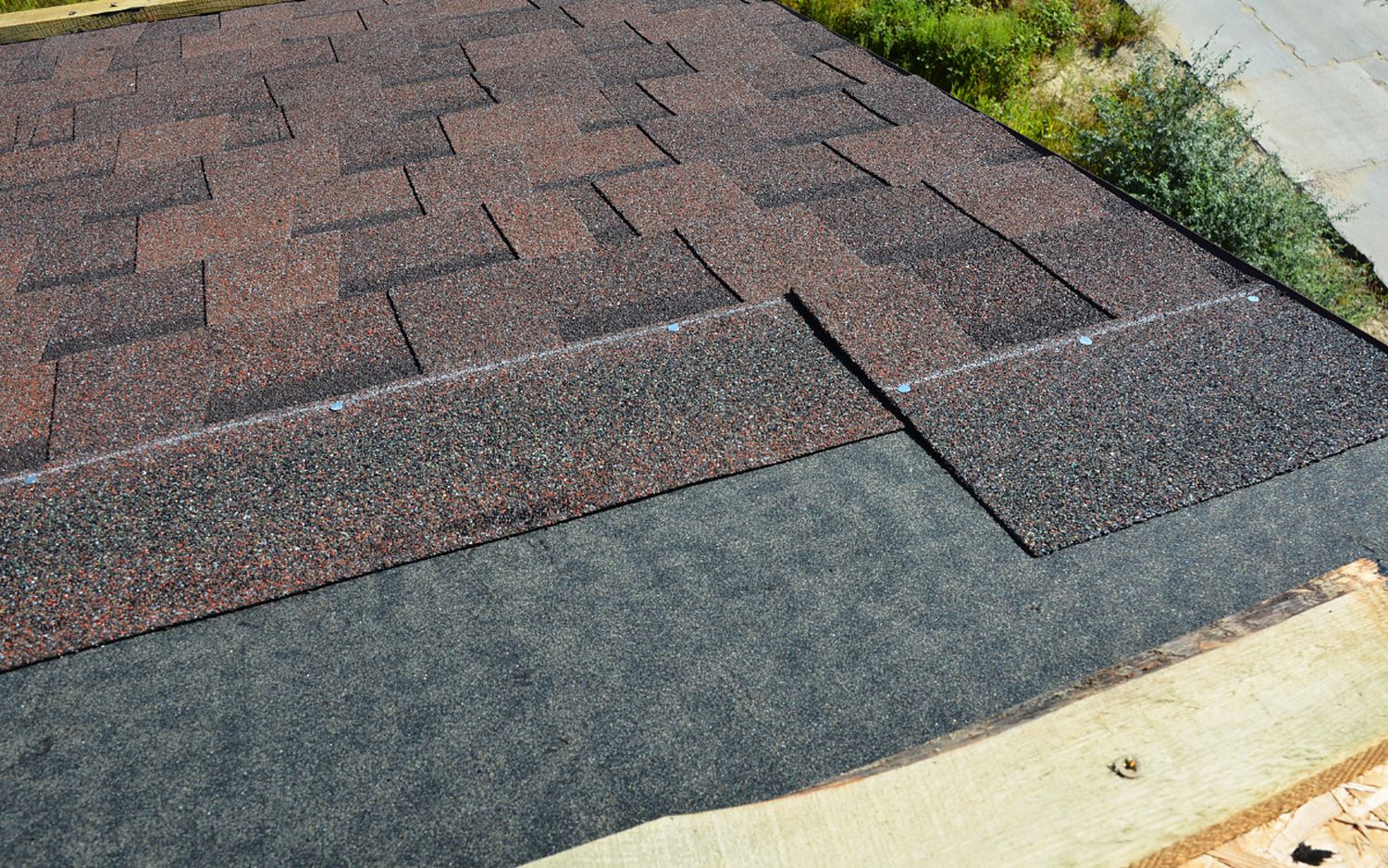Architectural asphalt shingles laid in courses, the laminated tabs throwing a deep shadow line