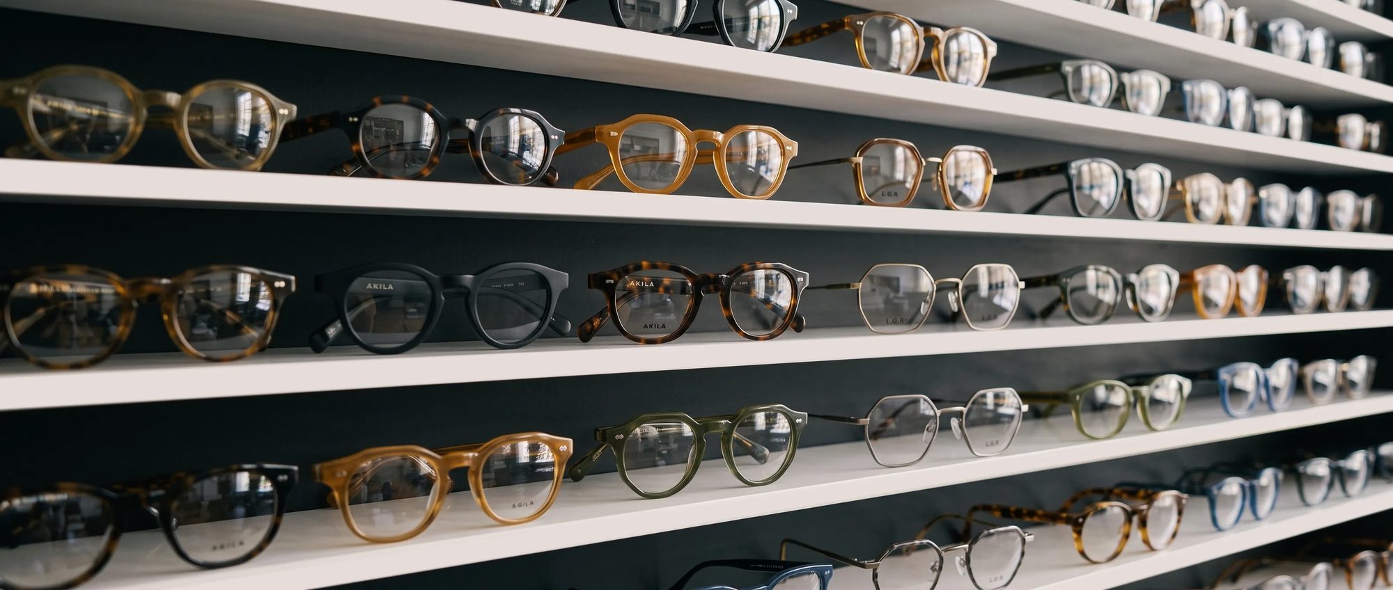 A wall of curated independent designer eyewear on display at Summerhill Optometry