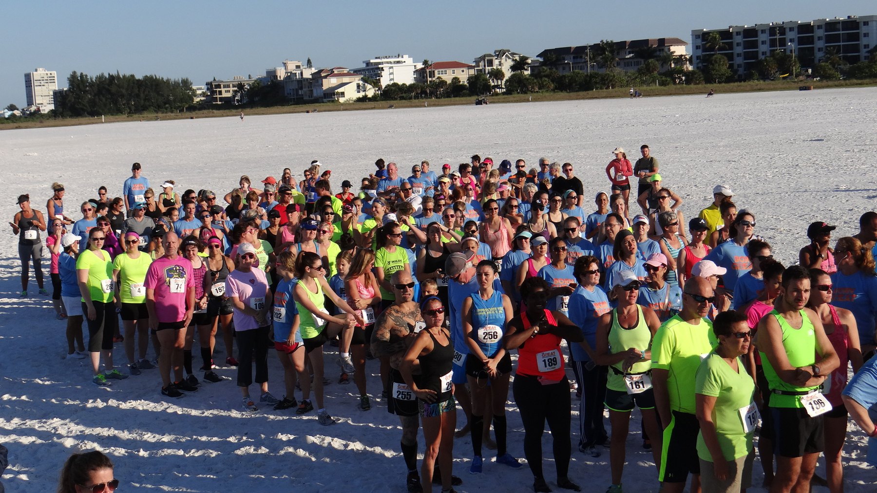 Runners massed at the starting line of a beach race