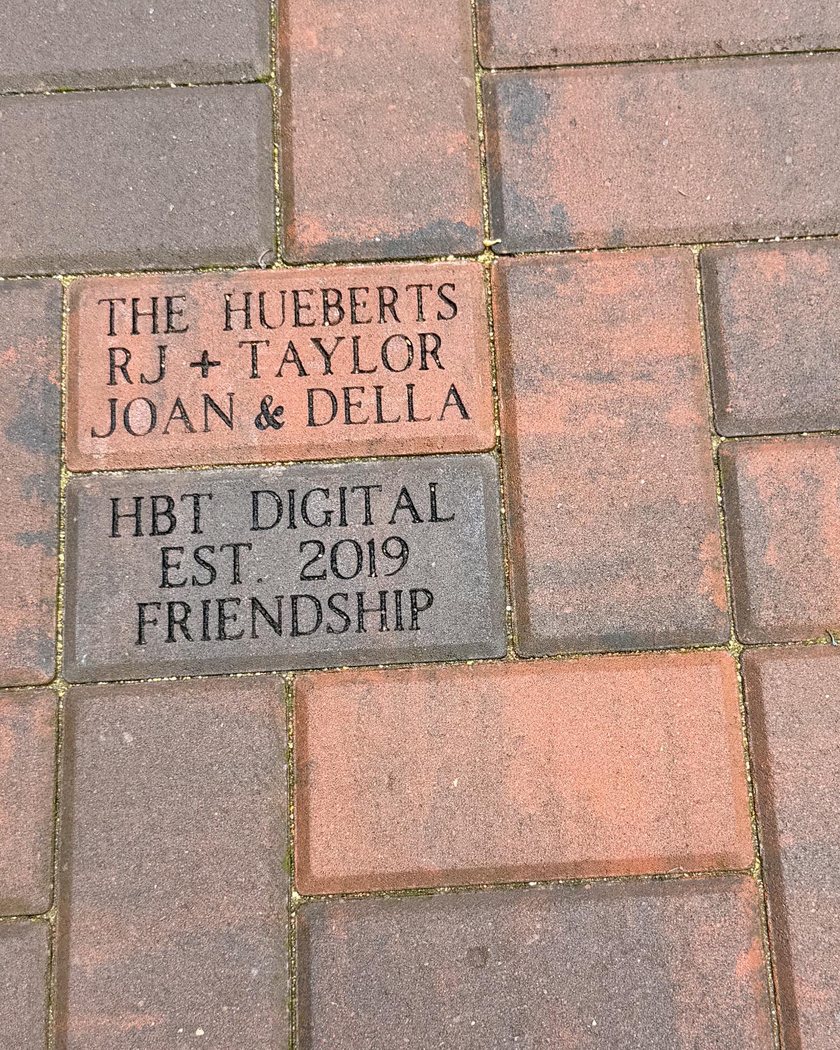 Engraved Pittsburgh pavers reading The Hueberts, RJ and Taylor, Joan and Della, above one reading HBT Digital, Est. 2019, Friendship
