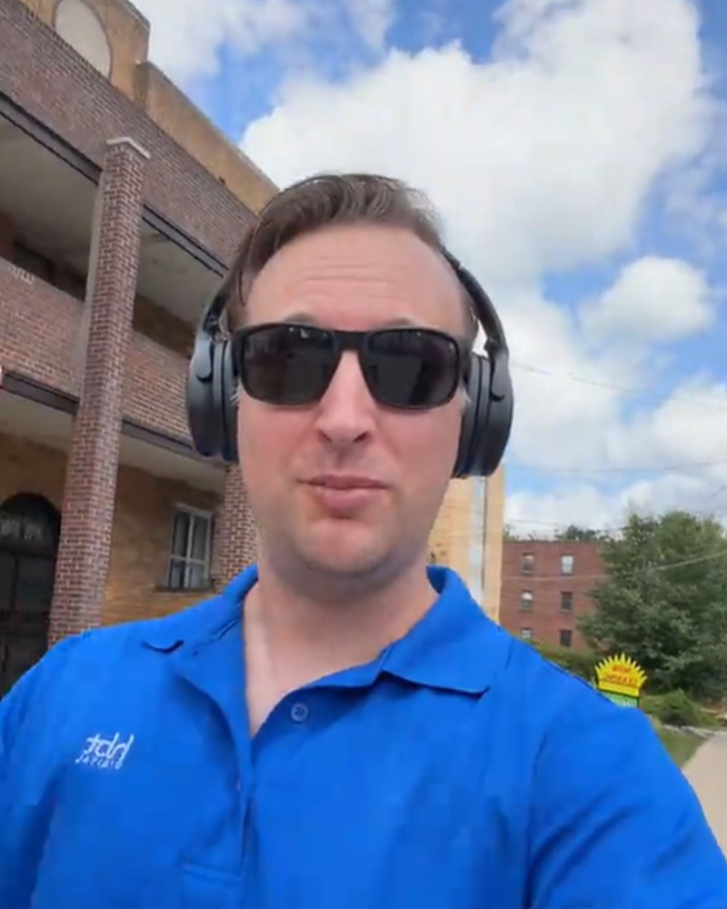RJ outdoors in a blue polo and headphones — thoughts on a walk in Shadyside