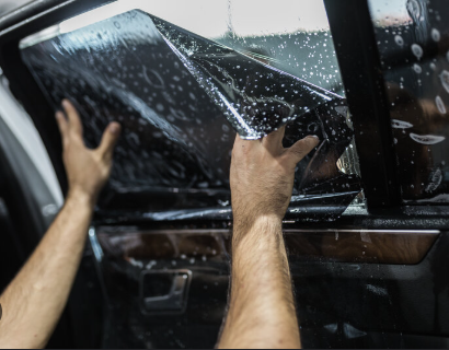 Technician installing automotive window film on a car door in Denver