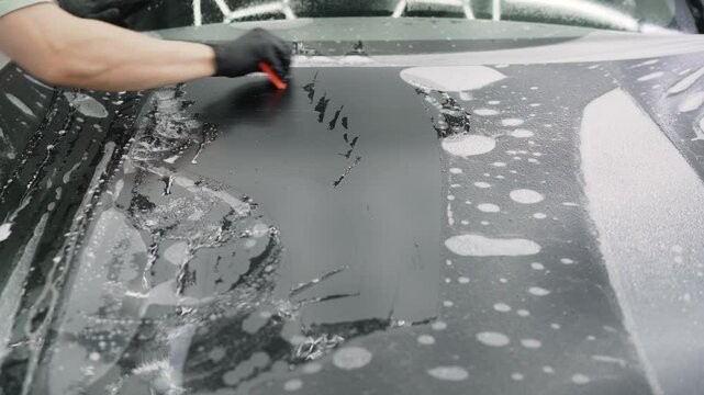 SUV in a professional studio receiving paint protection film on the front end