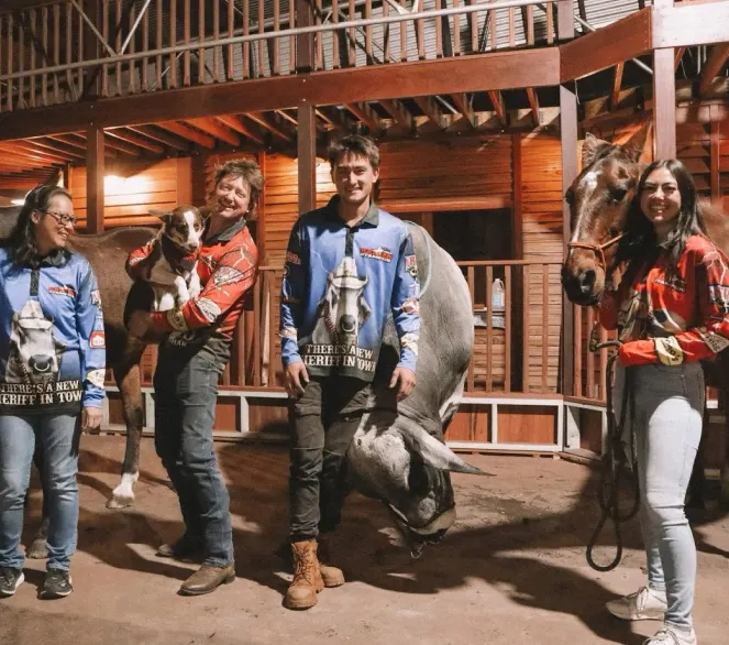 The owner family smiling together with their horses and dog