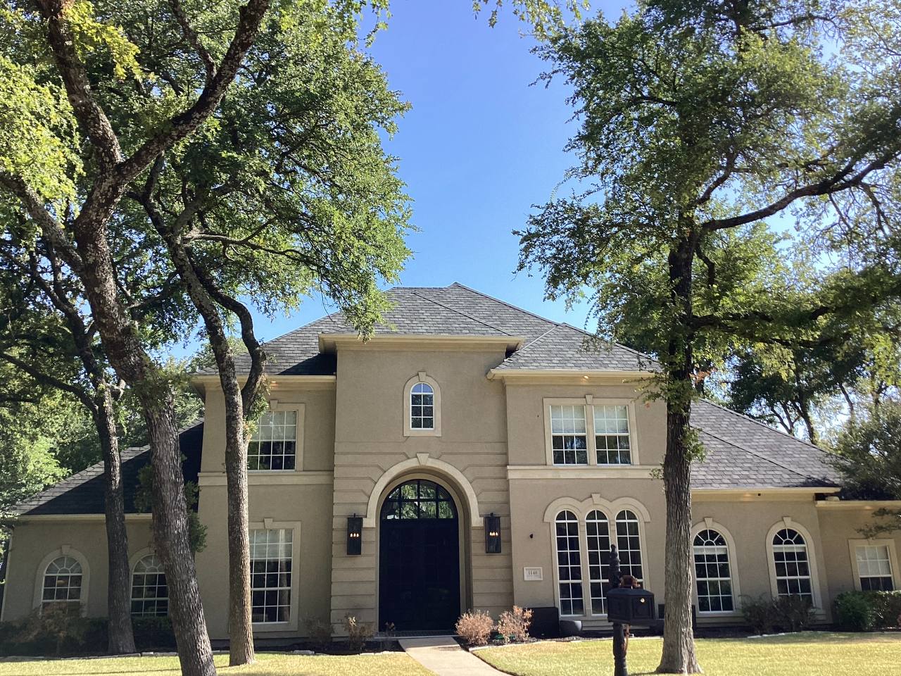 Distinctive Texas brick and stone estate home with manicured green lawn