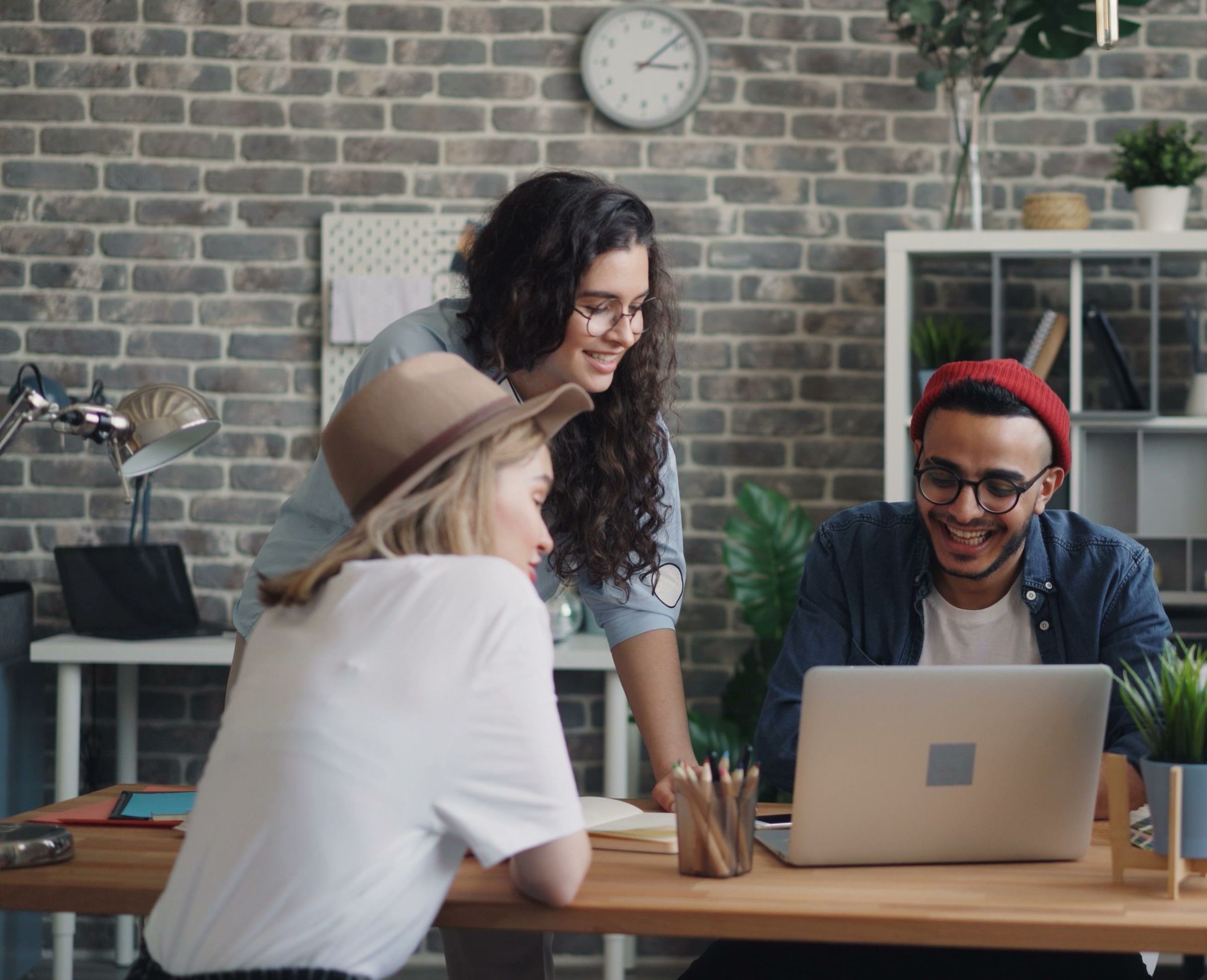 Three people smiling together at a laptop — the people who love you