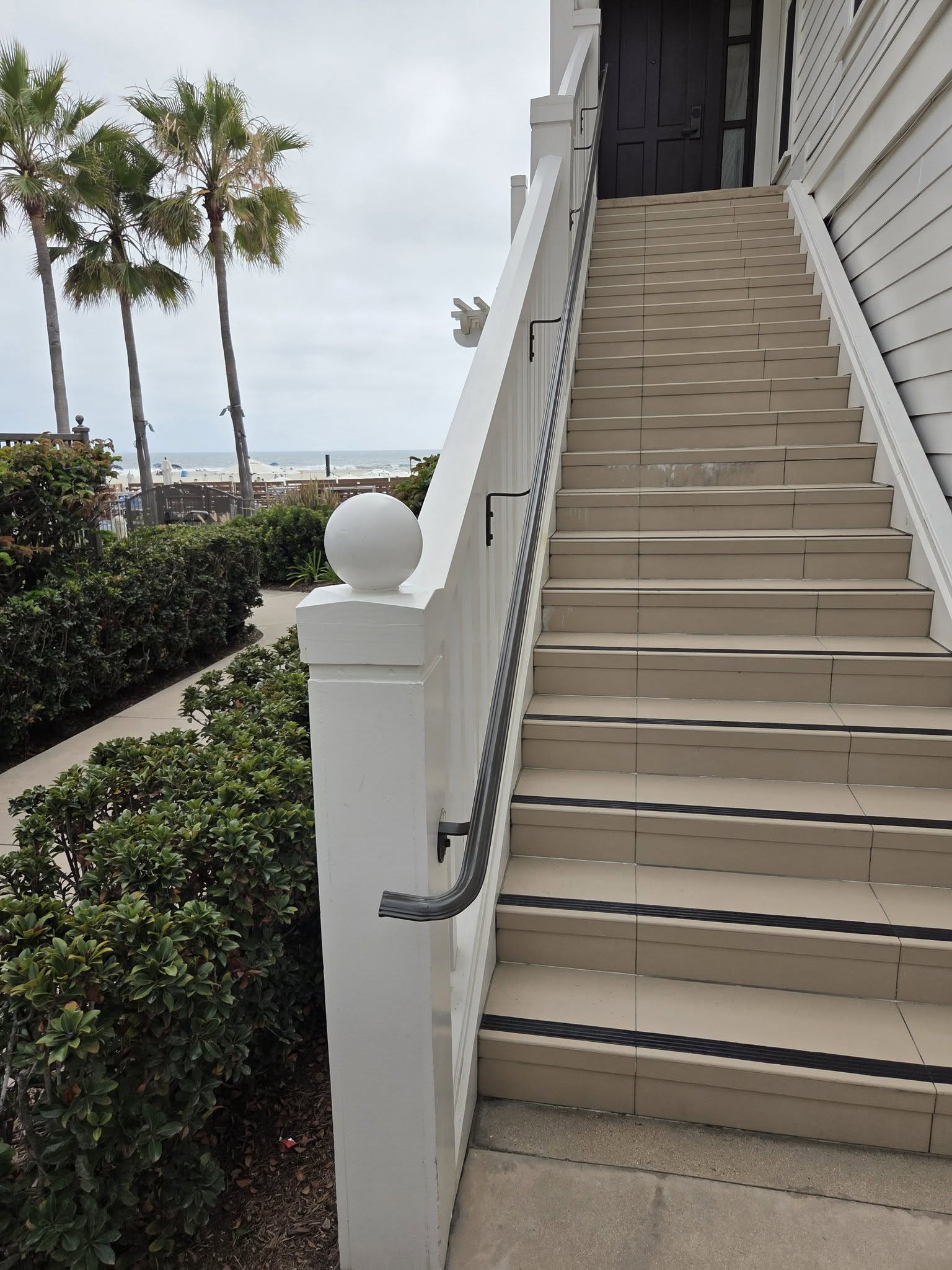 Custom dark metal handrail installed on an exterior staircase
