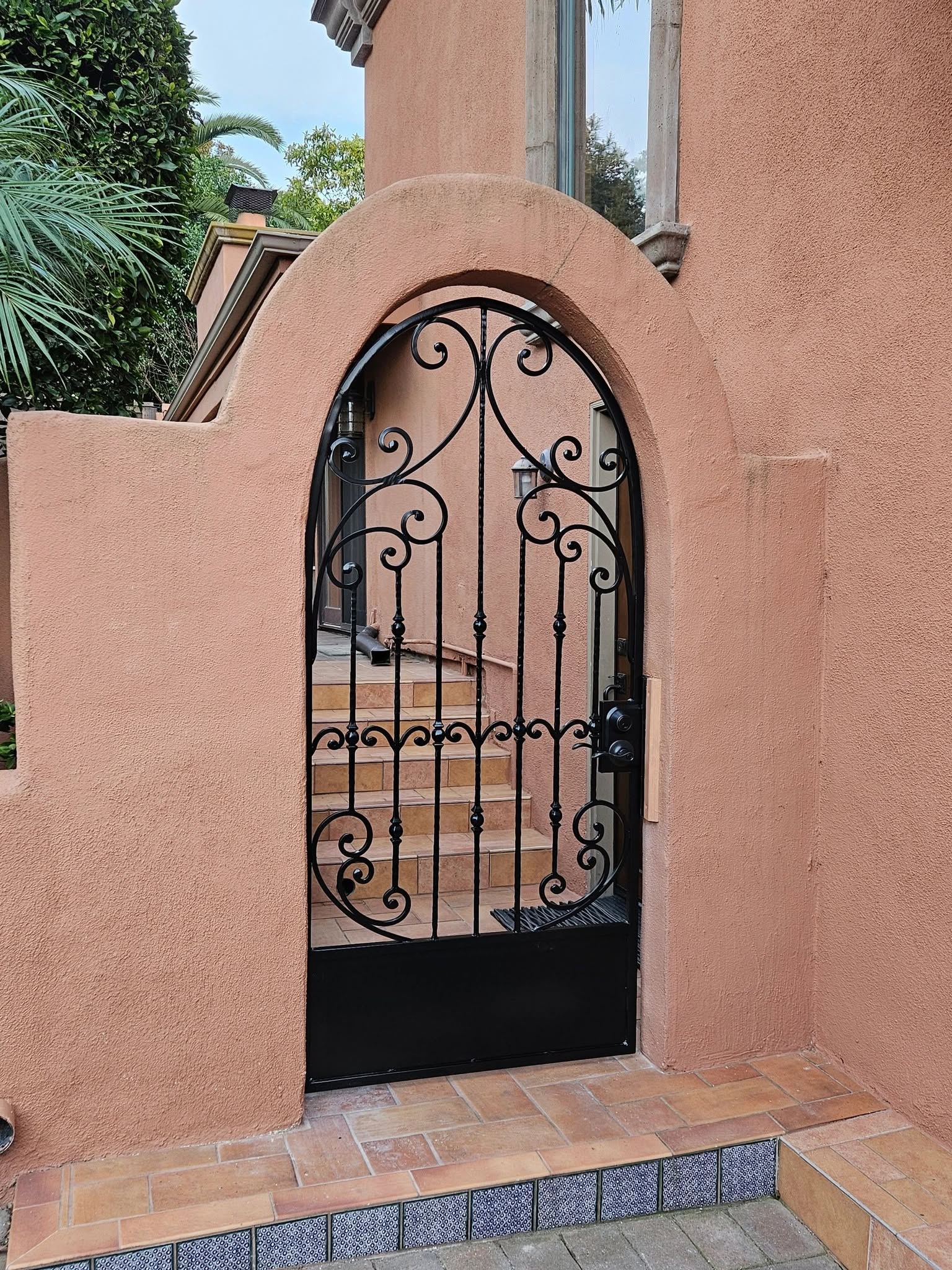 Ornamental arched wrought iron garden gate