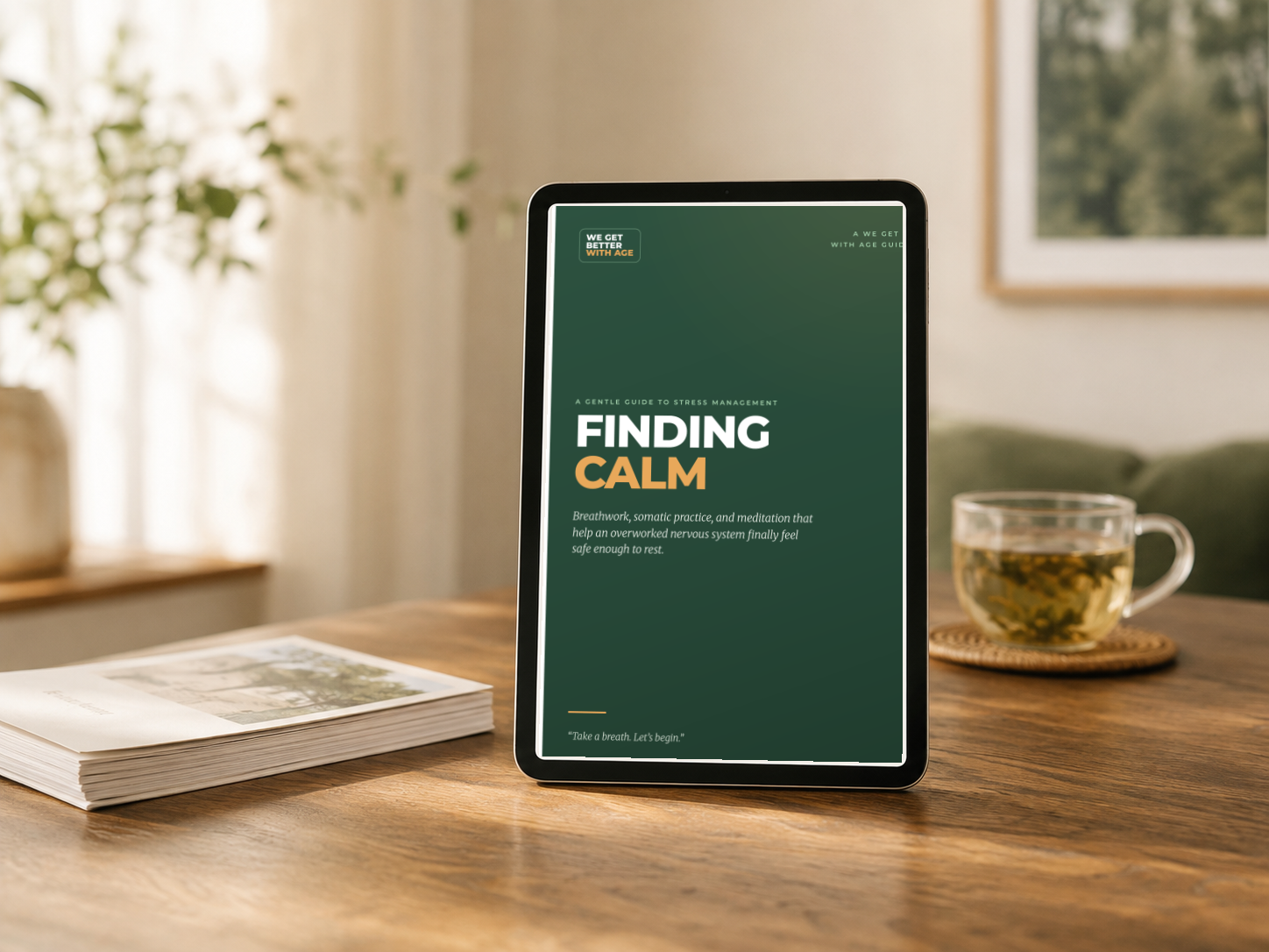 Finding Calm shown on a tablet on a warm wooden table beside printed pages and a cup of tea