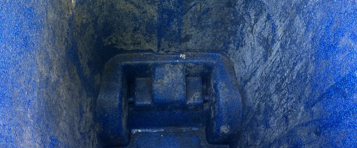 A close-up, downward view into the textured, dusty blue plastic interior of a container or bin.