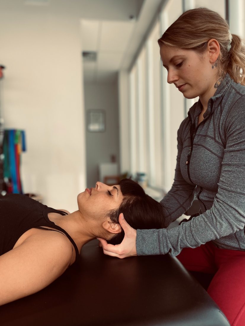 Victoria supporting a client’s head during fascial stretch therapy
