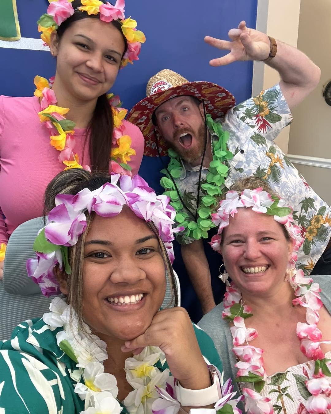 The Ritz Agency team wearing leis for Luau Day in the office