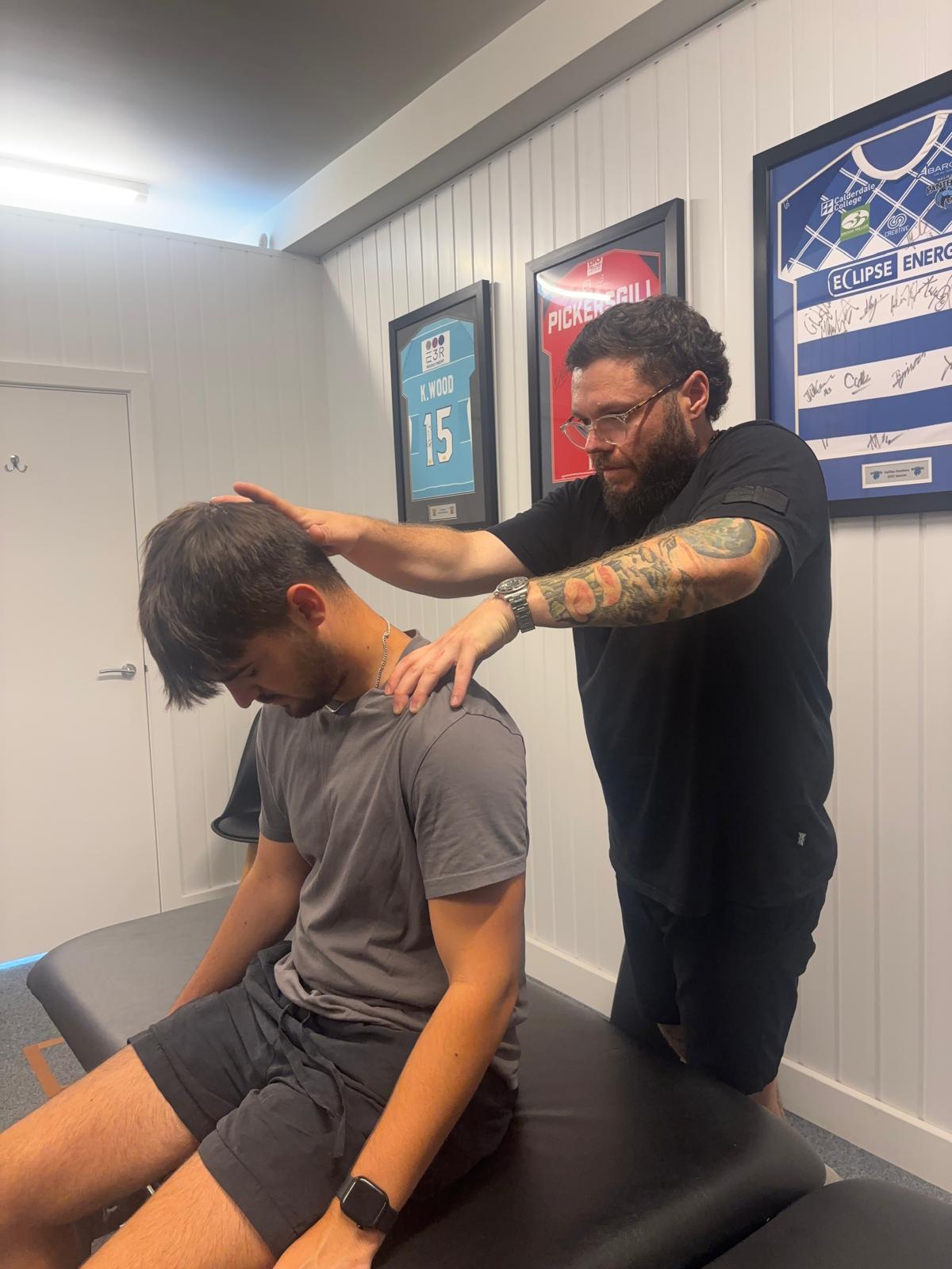 Valley Rehab therapist assessing a client's neck movement