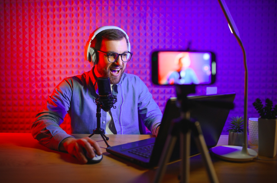Hosts recording a video podcast with a ring light and microphones