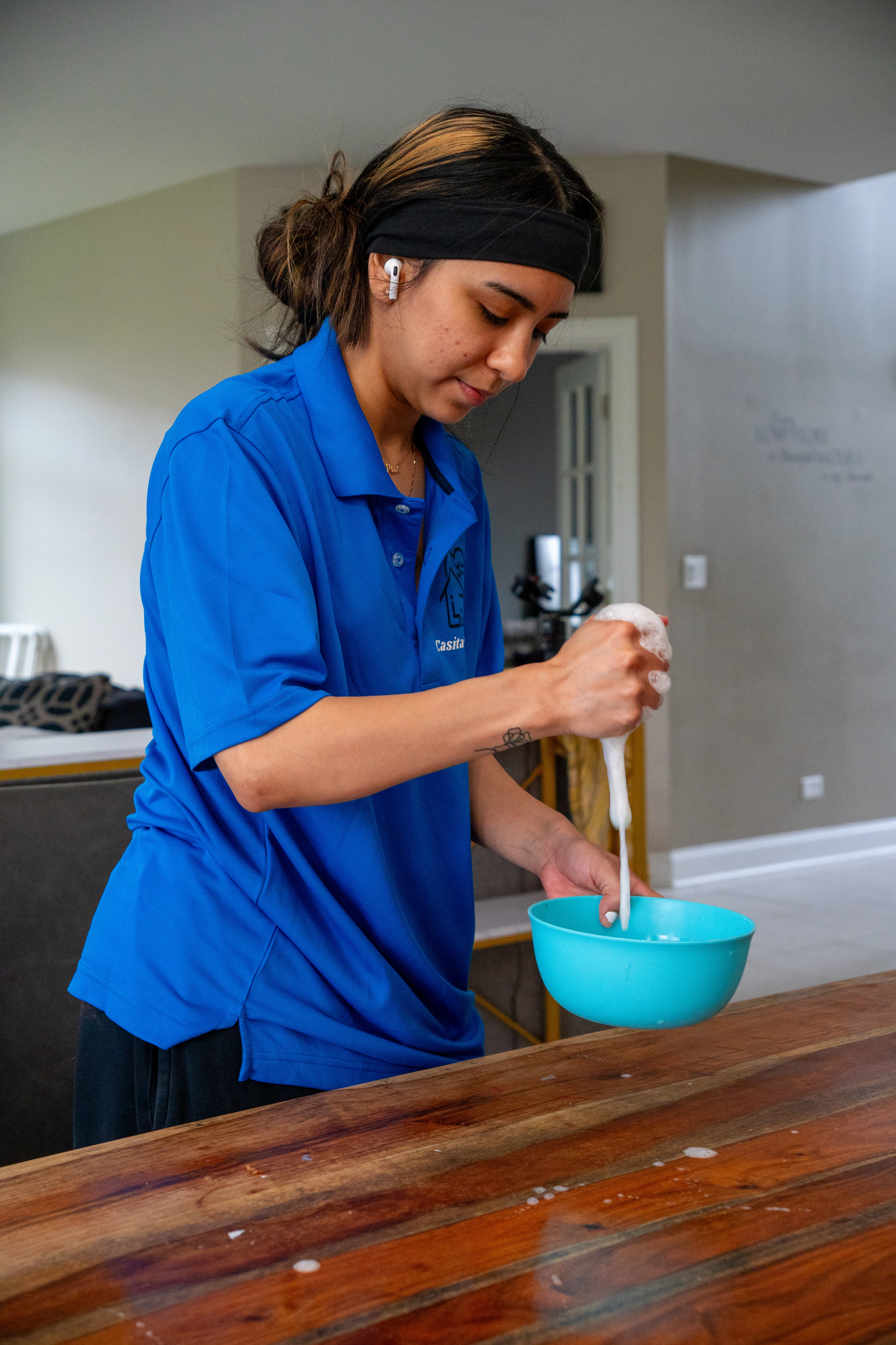 Casita Clean team member cleaning a wood table in a residential dining room in Mokena, IL