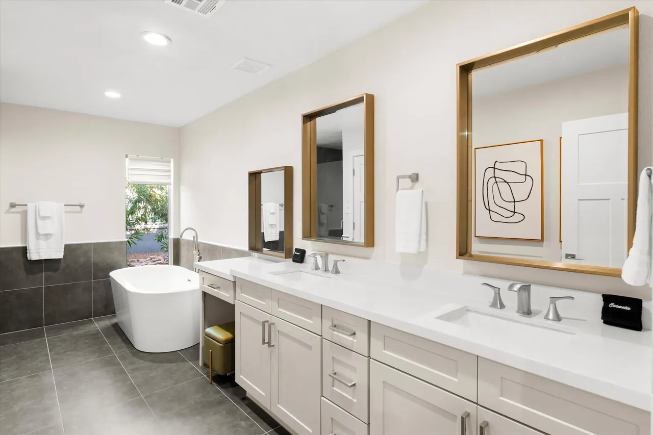 Remodeled primary bathroom with a freestanding tub and a long double vanity