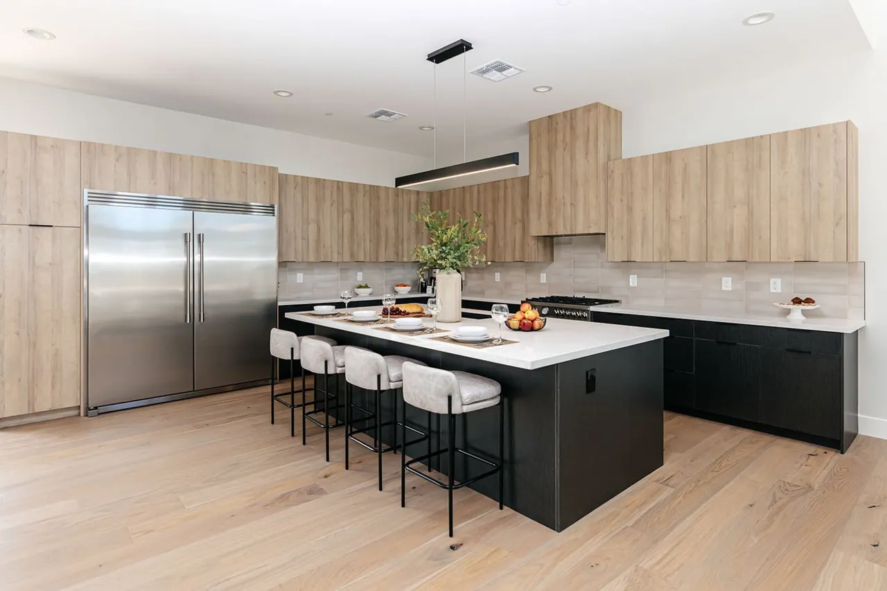 White kitchen with a large island and bar seating, remodeled by Logan Construction